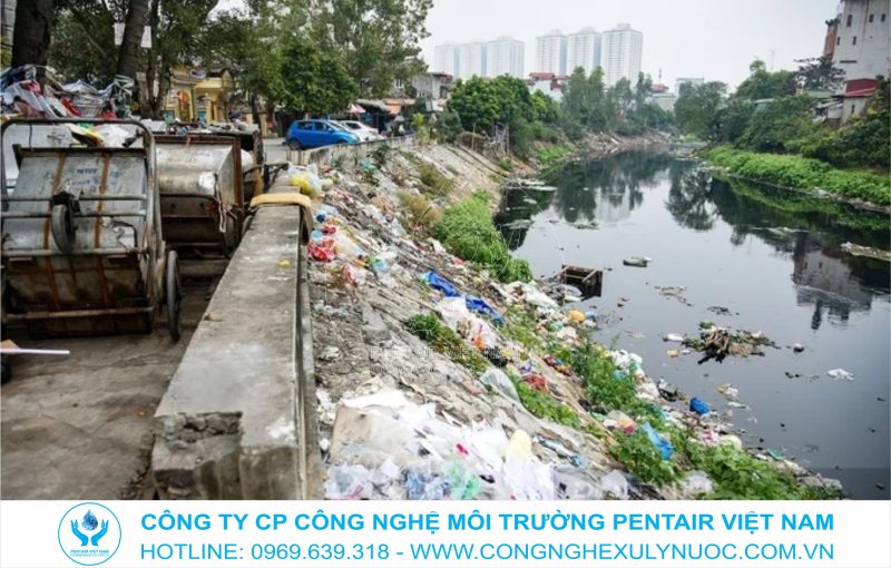 Hình ảnh dòng sông Tô Lịch đen đặc với rác thải nhựa và phế thải chất đống dọc bờ sông