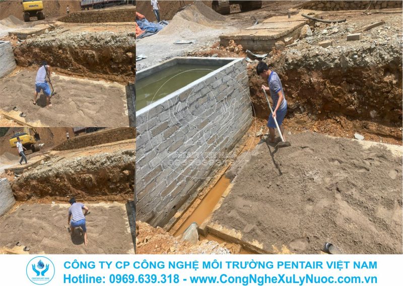 Công nhân dùng xẻng san gạt lớp cát mịn dưới đáy hố đào trạm xử lý nước thải mỏ sắt Đèo Gió, Bắc Kạn.