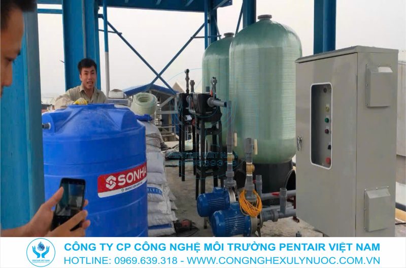 Hai công nhân đang lắp đặt cột lọc trong hệ thống lọc tổng nước giếng khoan công suất 10m3/h cho trang trại chăn nuôi lợn tập đoàn Masan tại Quỳ Hợp, Nghệ An.