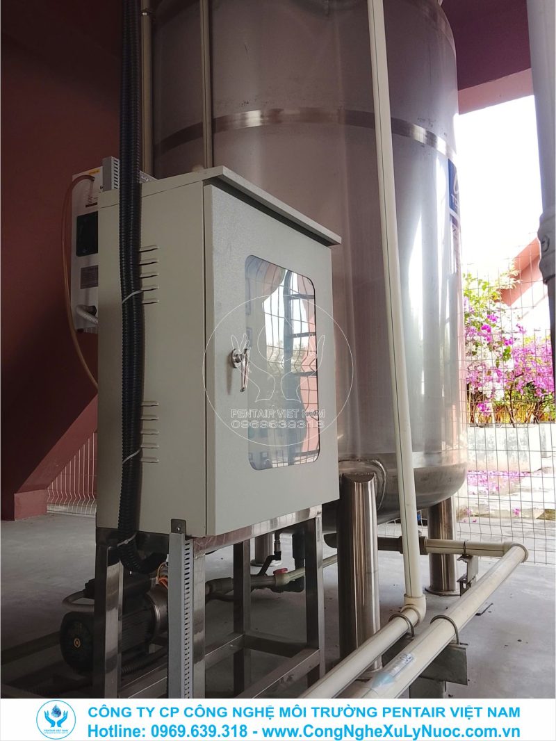 Kỹ thuật viên đang kiểm tra đấu nối tủ điện điều khiển trung tâm hệ thống lọc nước R/O 4m3/h tại trường Marie Curie Việt Hưng.
